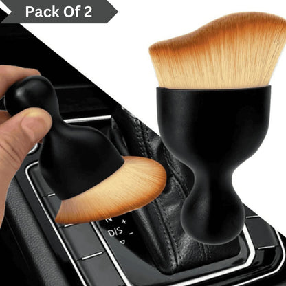 Two makeup brushes with black handles and wooden bristles on a car gear shift.